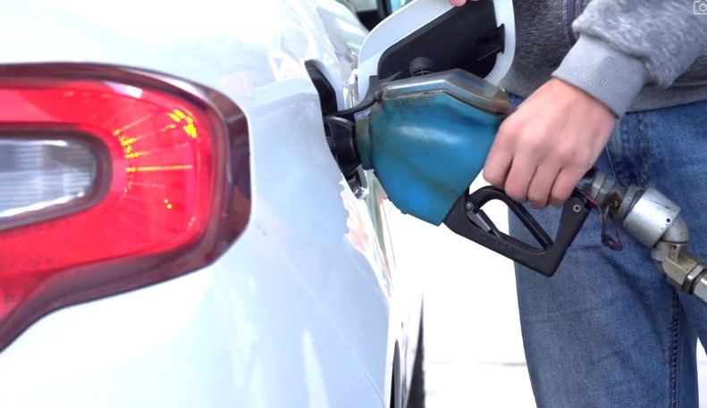 Čovek toči gorivo u rezervoar na benzinskoj pumpi
