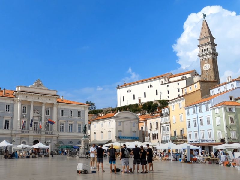 Tartinijev trg u Piranu sa crkvom sv. Jurija i prepoznatljivim zvonikom u pozadini.