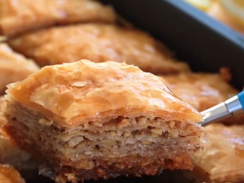 devojka vadi baklavu iz tepsije